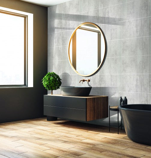 Modern bathroom with black freestanding bathtub, wooden vanity, and round mirror.